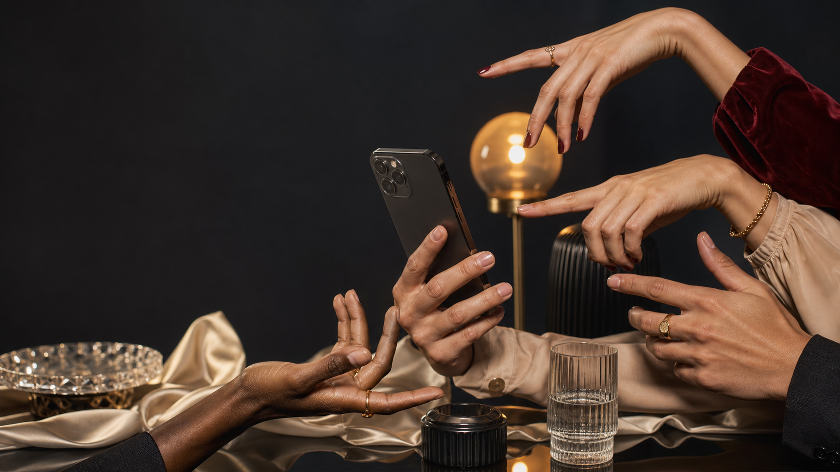 Well-groomed hands posing around a smartphone in a premium studio setting.